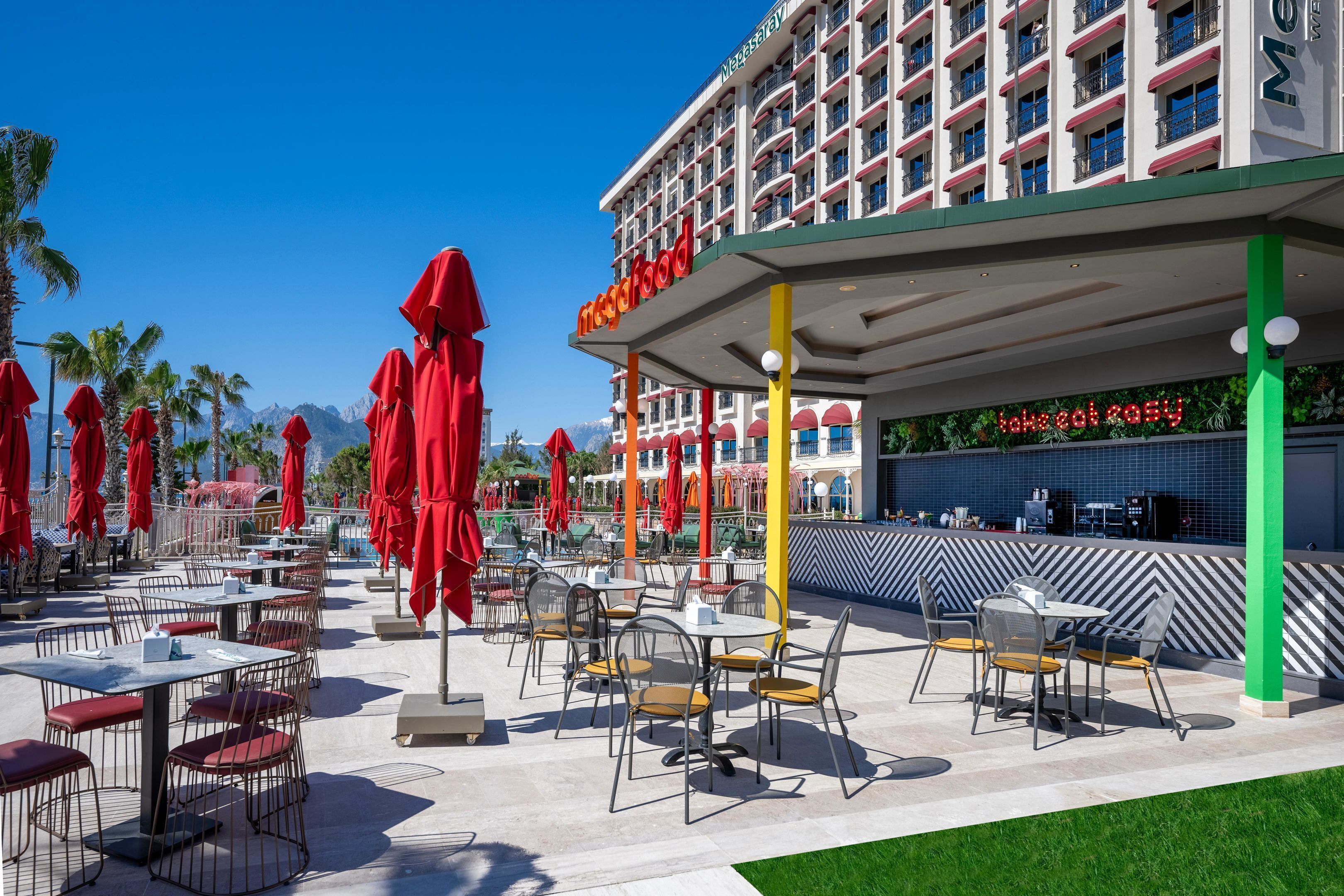 A hotel with outdoor seating and a view of mountains.