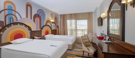 Habitación de hotel con dos camas, un escritorio, una silla, un espejo grande y un diseño abstracto y colorido en la pared.