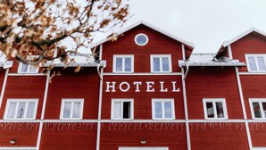 Un edificio rojo con la palabra 'HOTEL' en la fachada.
