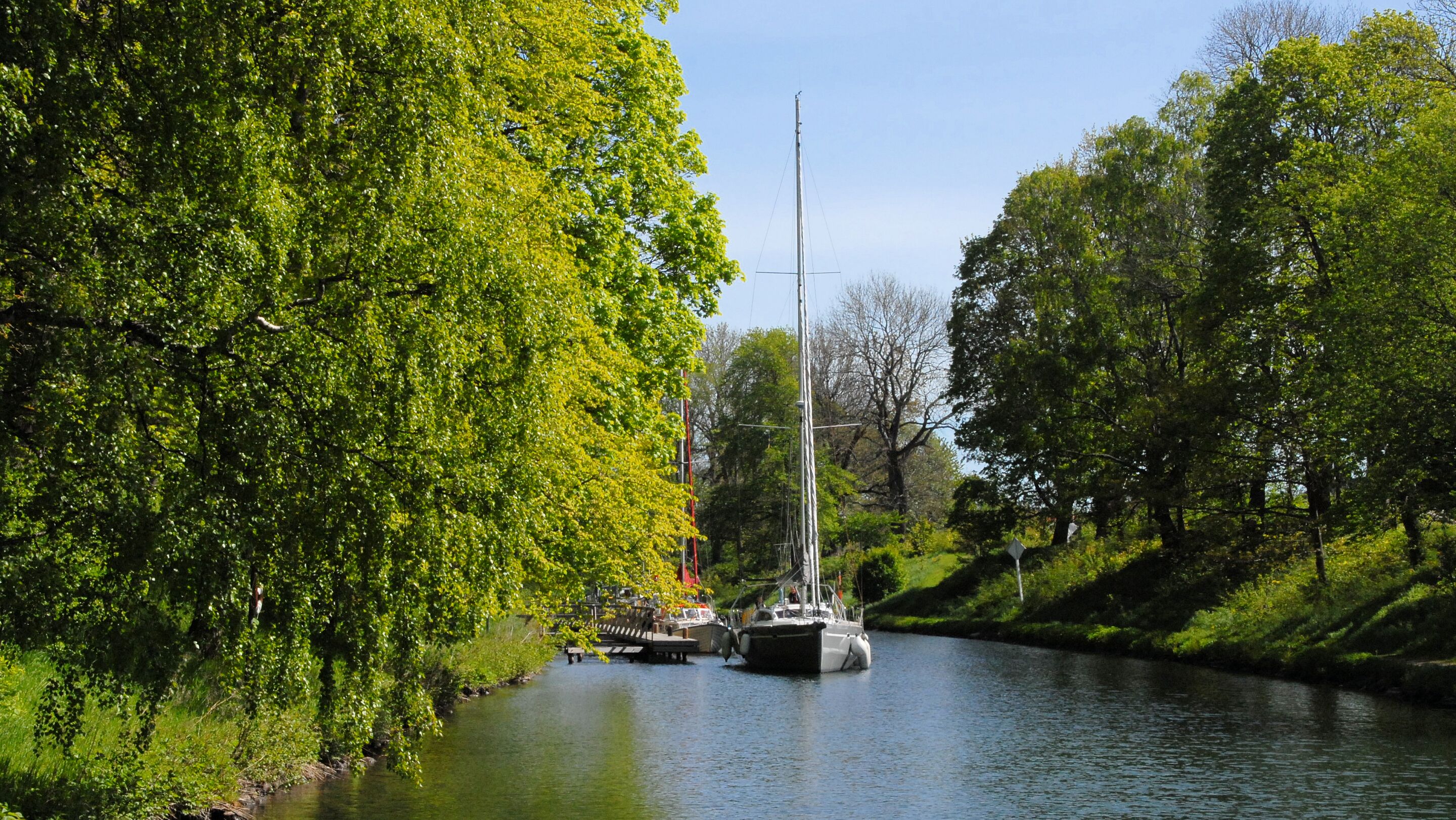 A river with boats and lush greenery on both sides.