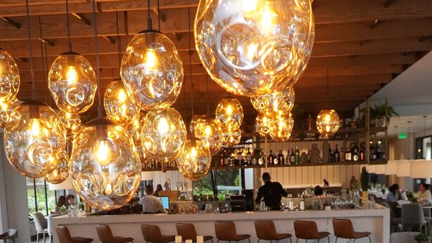 A restaurant interior with round tables, chairs, and hanging spherical light fixtures. - Hotel Estelar El Cable (Manizales)