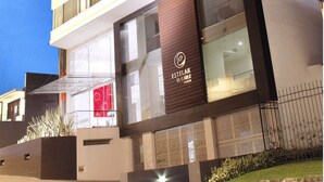 A multi-story hotel with a modern design, featuring a prominent entrance with a glass facade and a logo. - Hotel Estelar El Cable (Manizales)
