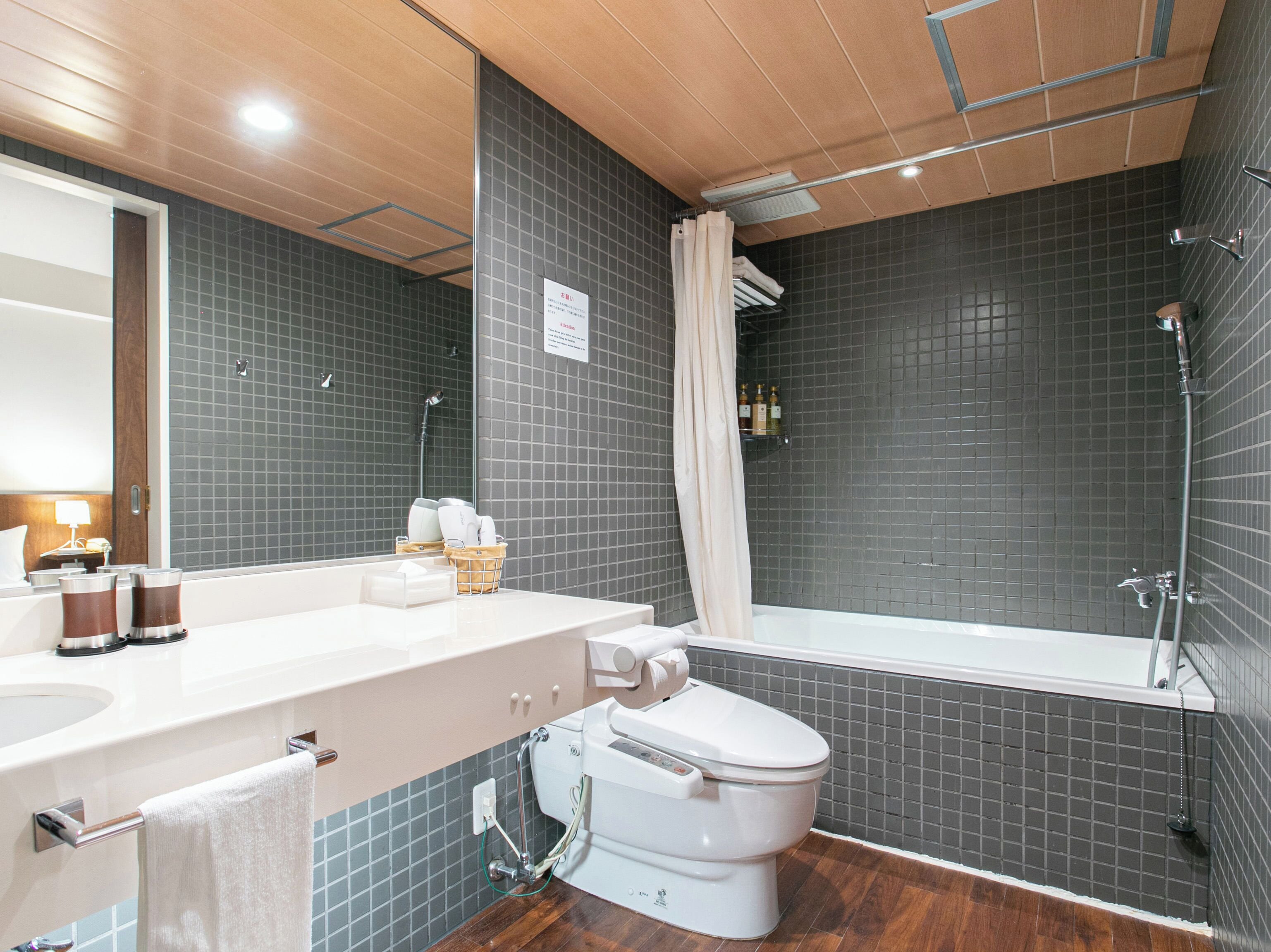 A modern bathroom with a white toilet, a sink, and a bathtub.