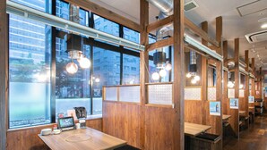 A restaurant interior with wooden walls, large windows, and pendant lighting. - Sutton Hotel Hakata City (Fukuoka)