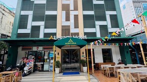 A hotel with a modern facade, a central entrance, and a covered outdoor seating area. - The Legacy Hotel Nana Sukhumvit, Aspira Collection (Bangkok)