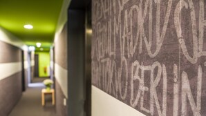 Un couloir avec un plafond vert et un mur sur lequel sont inscrites en grandes lettres blanches le mot « BERLIN ».