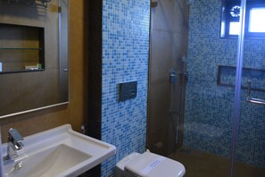 Un baño con lavamanos, inodoro y ducha.