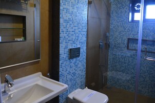 Un baño con lavamanos, inodoro y ducha.