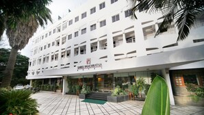 A multi-story hotel with a modern facade, a well-maintained entrance area, and a tiled patio.