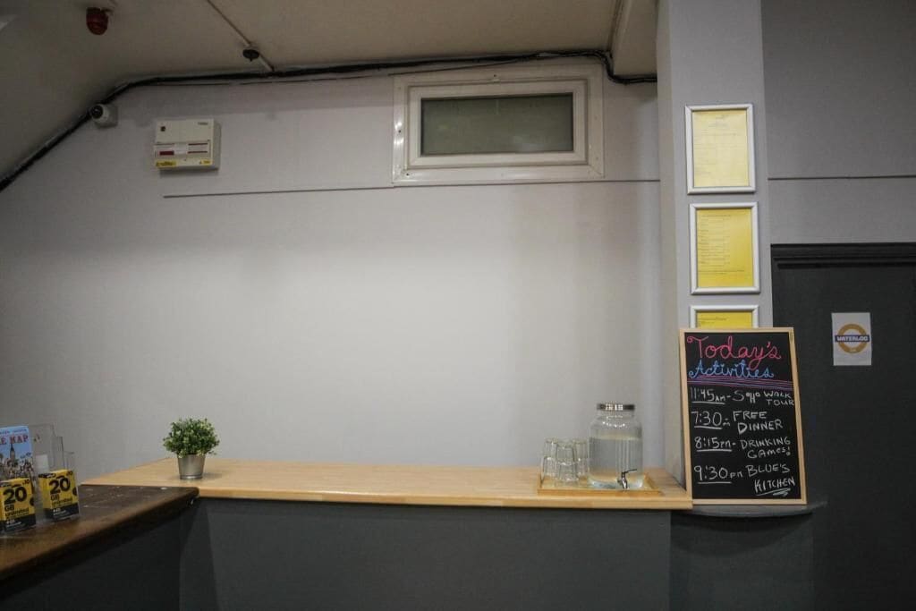 A reception area with a chalkboard displaying today's activities, a small plant, and a water dispenser.