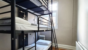 A bunk bed room with a window, a radiator, and a wooden floor. - Onefam Waterloo 18-36 years old (London)