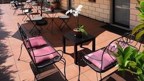 An outdoor patio area with tiled flooring, metal furniture, and potted plants. - Villa Santa Croce (San Giovanni Rotondo)