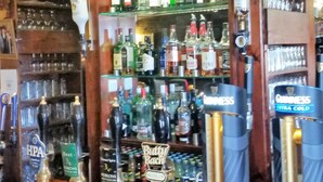 A bar area with shelves of liquor bottles, a display of beer taps, and a counter with a menu. - The Bull's Head Inn at Chelmarsh (Bridgnorth)