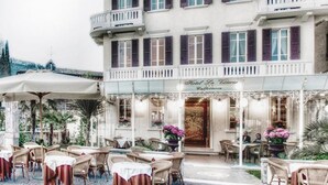 A hotel with outdoor seating, a balcony, and a sign reading "Hotel La Vittoria". - La Vittoria Boutique Hotel (Garda)