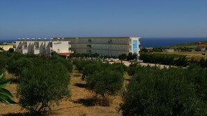 A hotel with multiple floors, a prominent blue sign, and a view of the sea. - Chrissy's Paradise (Malevizi)