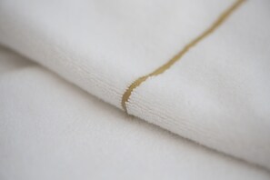 A close-up of a white fabric with a golden seam. - I Piastroni Hotel & SPA (Monteverdi Marittimo)