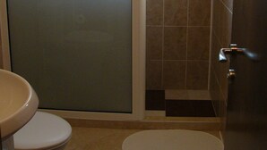 A bathroom with a toilet, a sink, and a shower stall. - Apartment Gurguliat Sofia (Sofia)