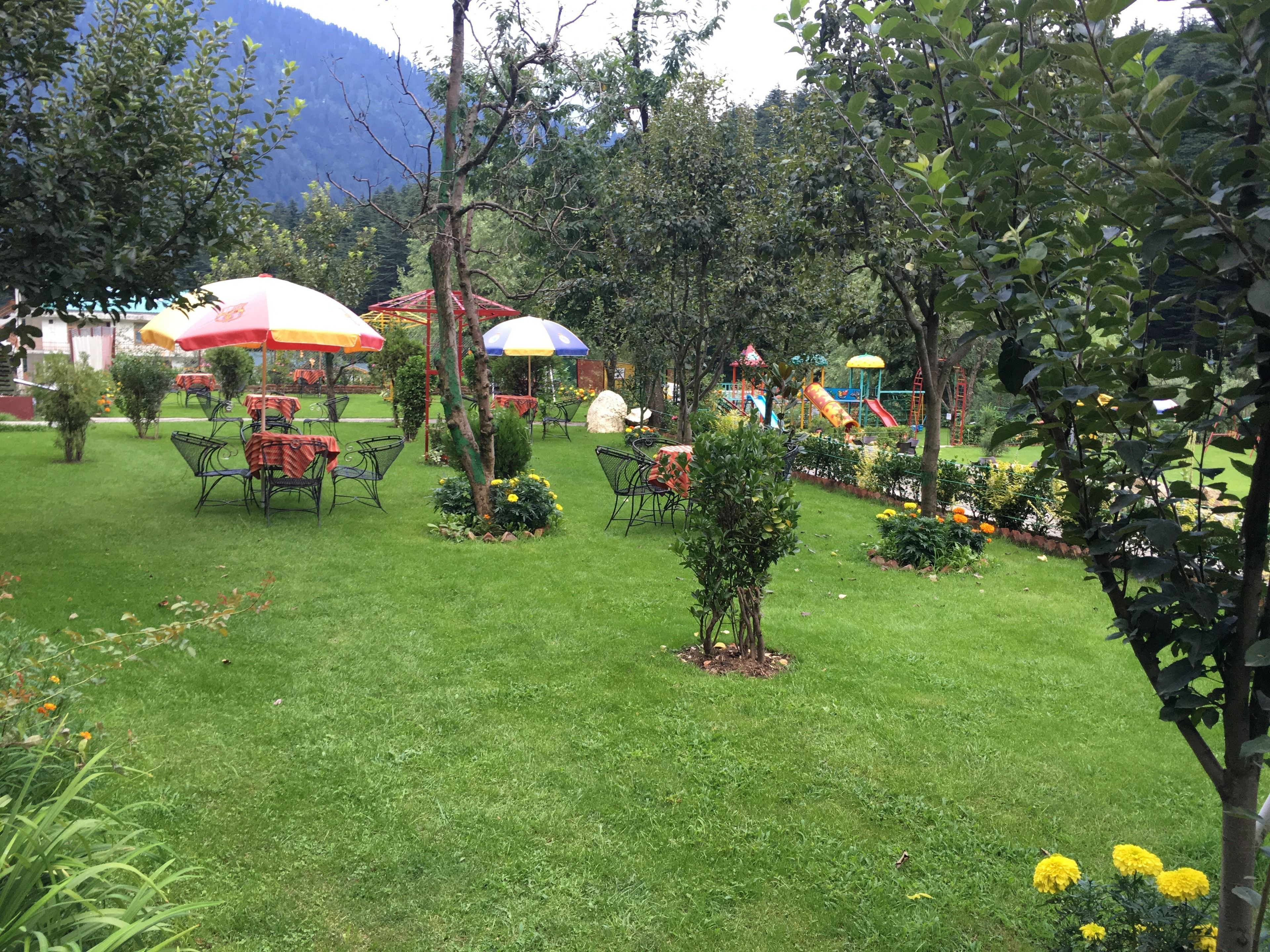 Ein gepflegter Garten mit Sitzgelegenheiten und einem Spielplatz.