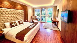 Quarto de hotel moderno com uma cama grande, televisão e vista para o exterior.