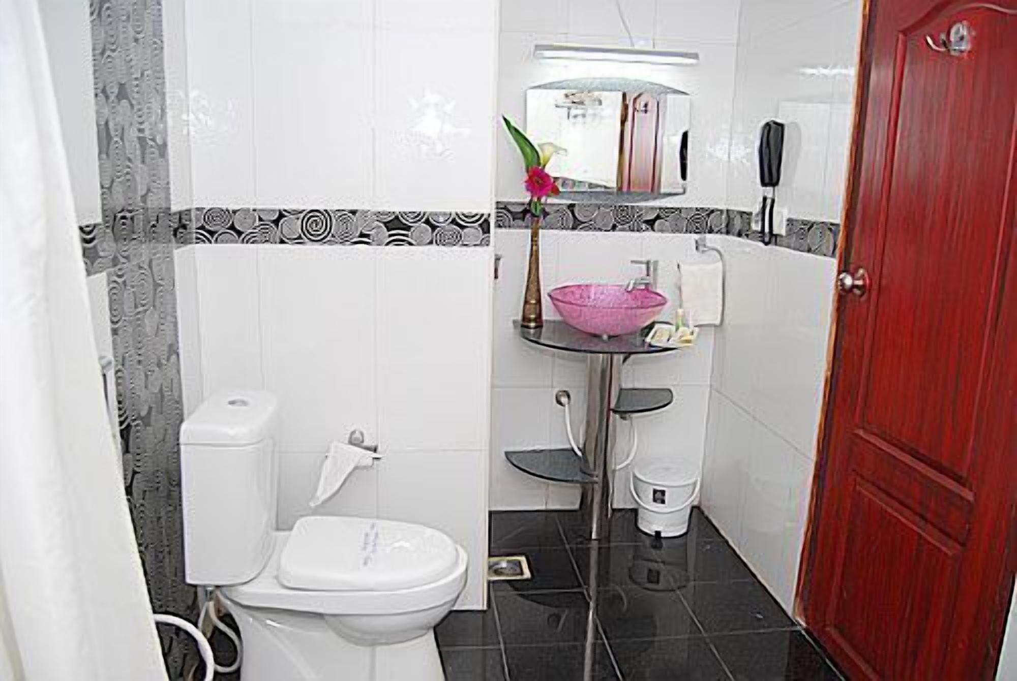 A compact bathroom with a toilet, sink, and bidet.
