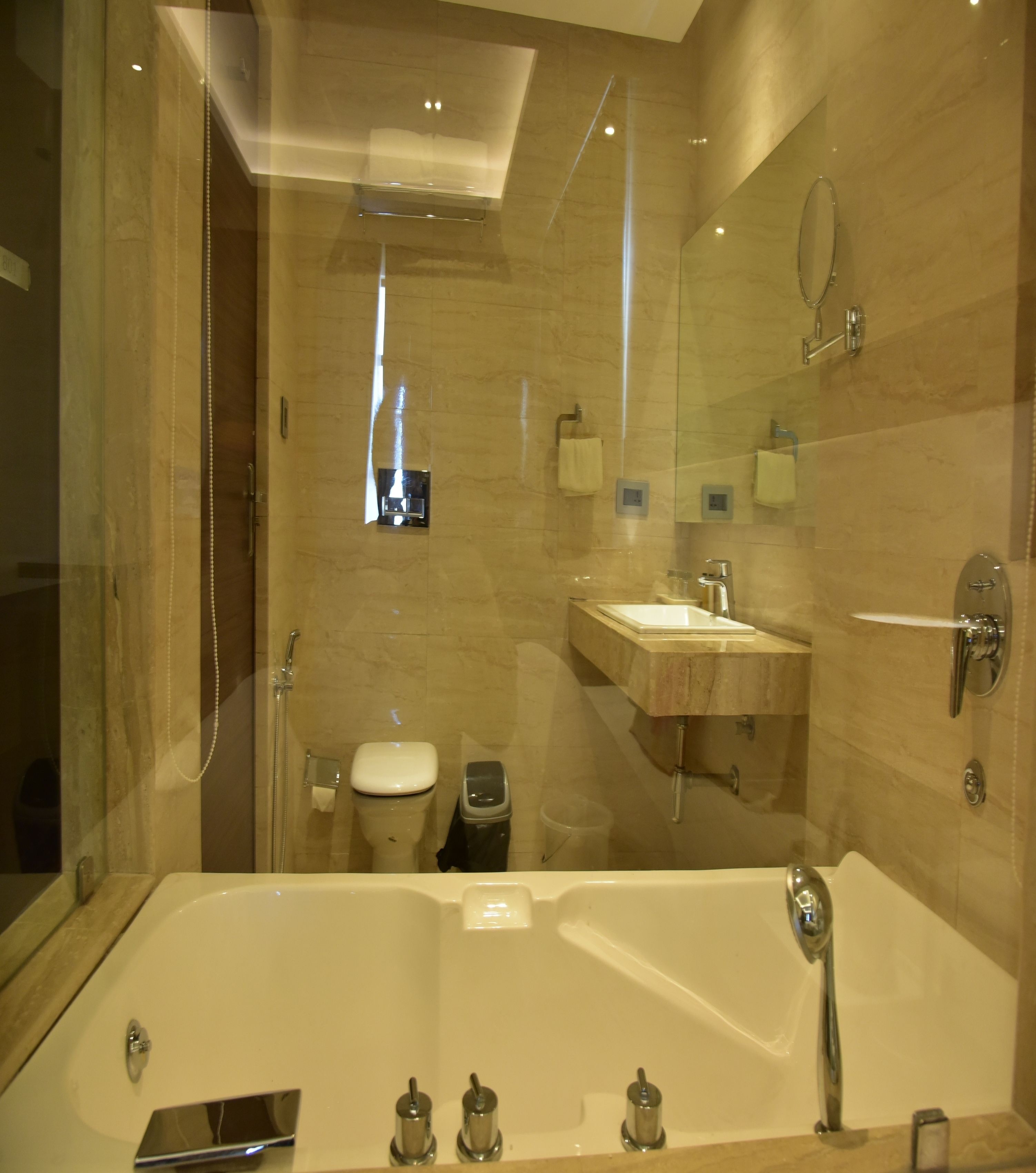 A modern bathroom with a large bathtub, a toilet, and a sink.