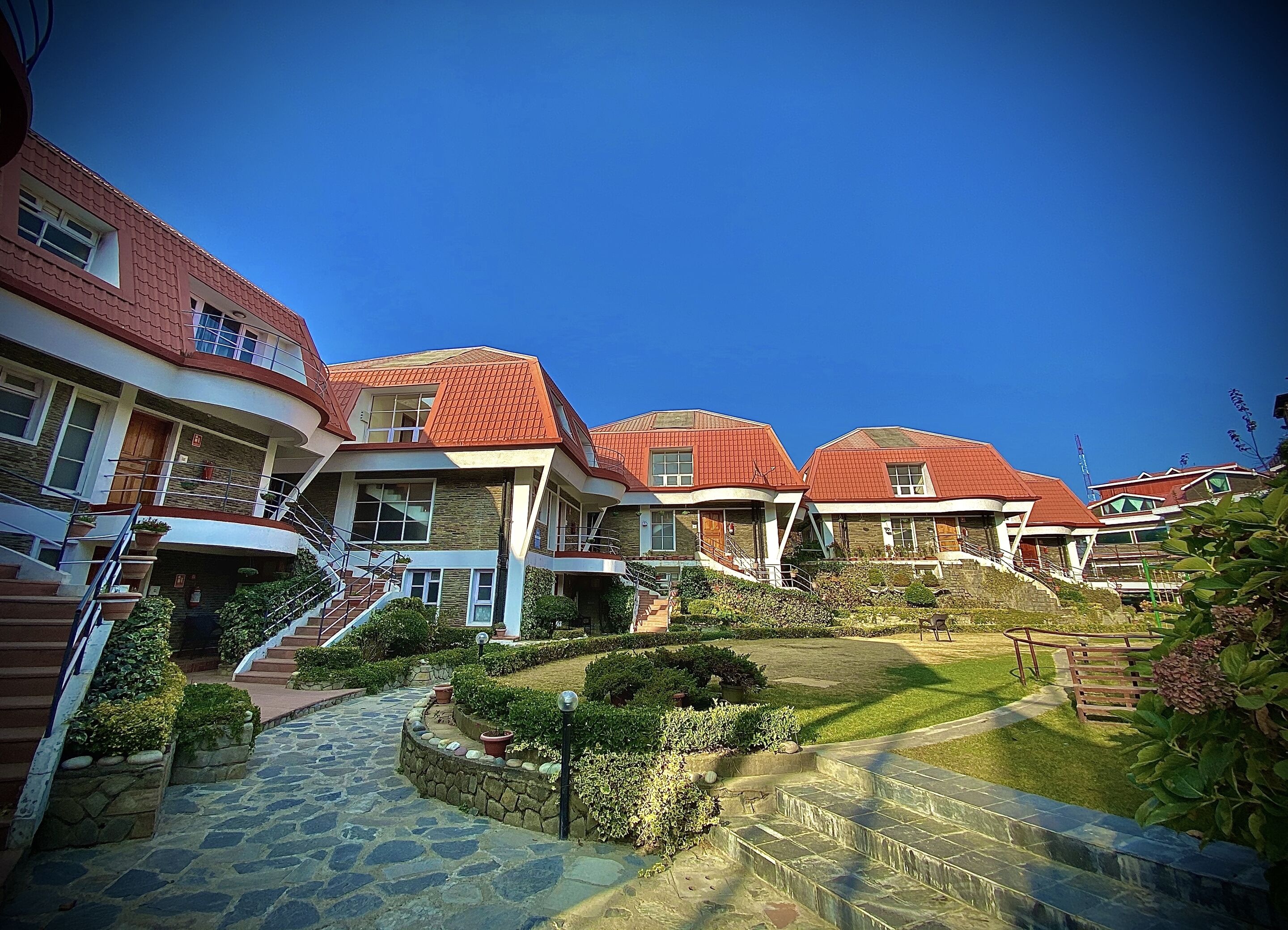 A row of houses with red roofs and stone pathways.