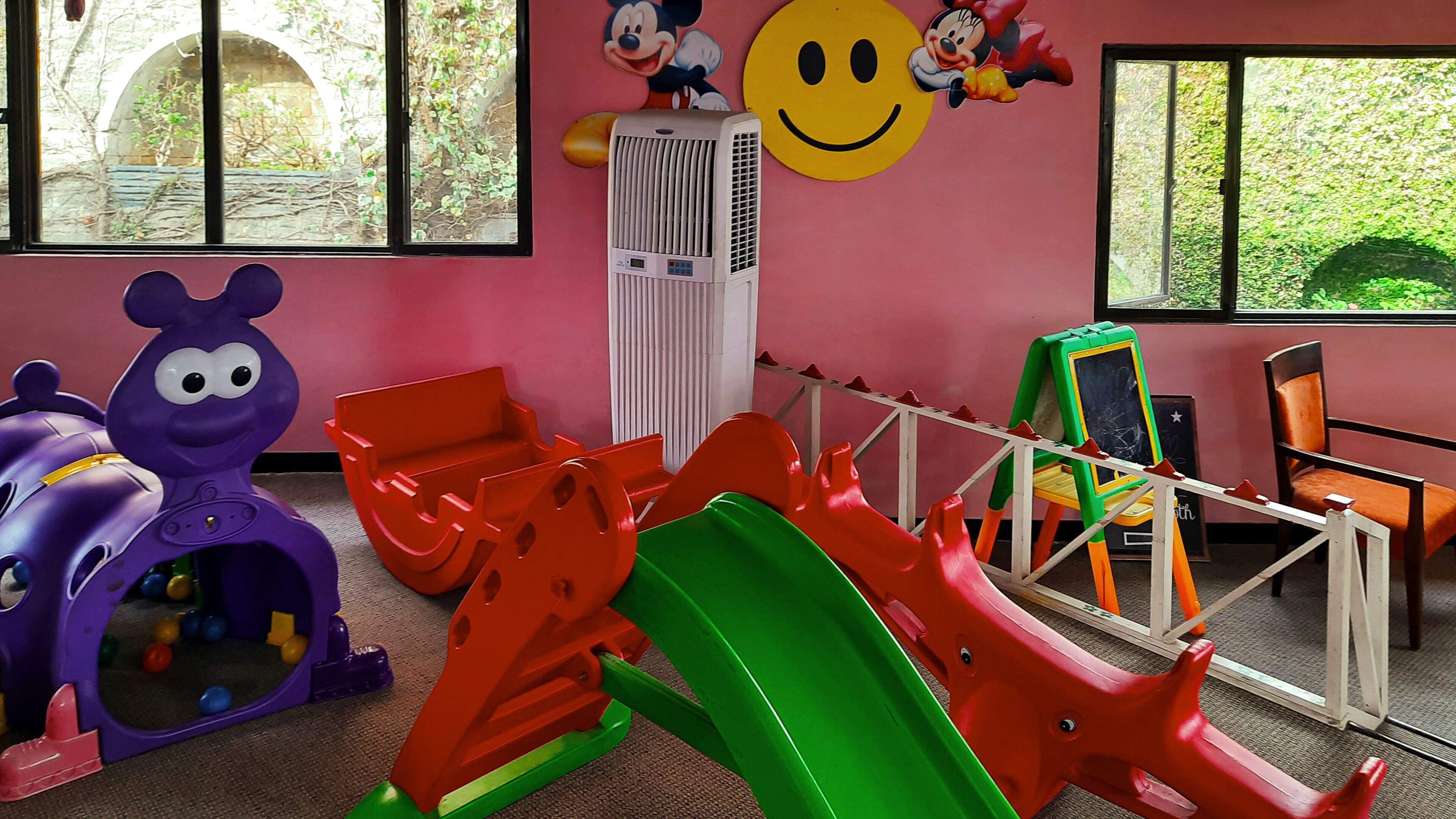 A play area with colorful slides and a purple toy car.
