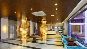 A lobby with marble flooring, a reception desk, and seating areas. - Marigold Sarovar Portico , Shimla. Heated pool & AC Rooms (Resort cottage and SPA) (Shimla)