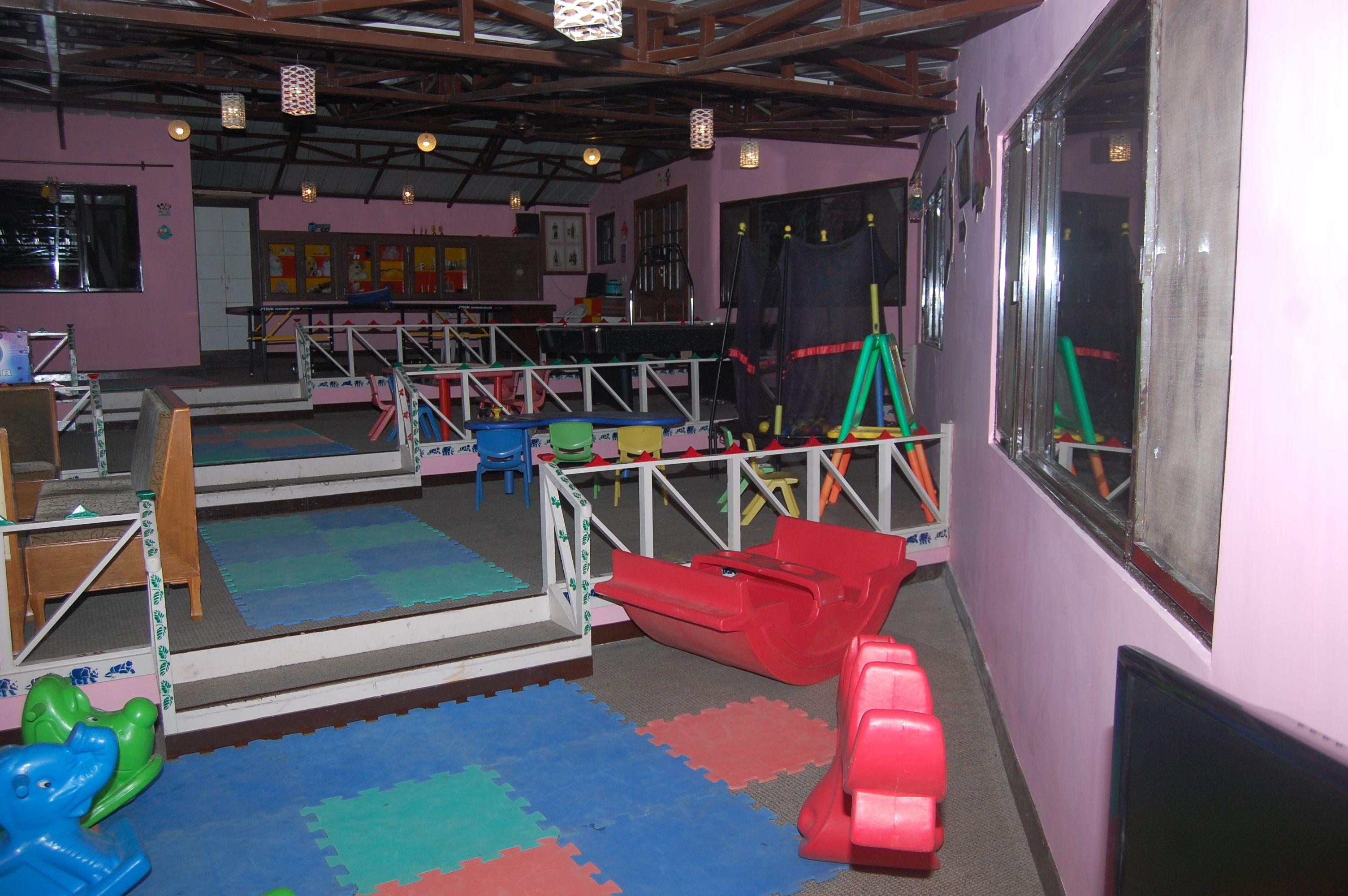 A play area with colorful mats, a slide, and a climbing structure.