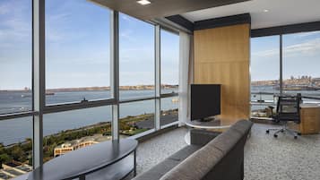 Un espacio de oficina moderno con un amplio ventanal que ofrece vistas a un paisaje urbano frente al agua.