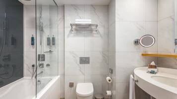 Un baño moderno con cabina de ducha de vidrio, inodoro blanco y tocador con espejo.