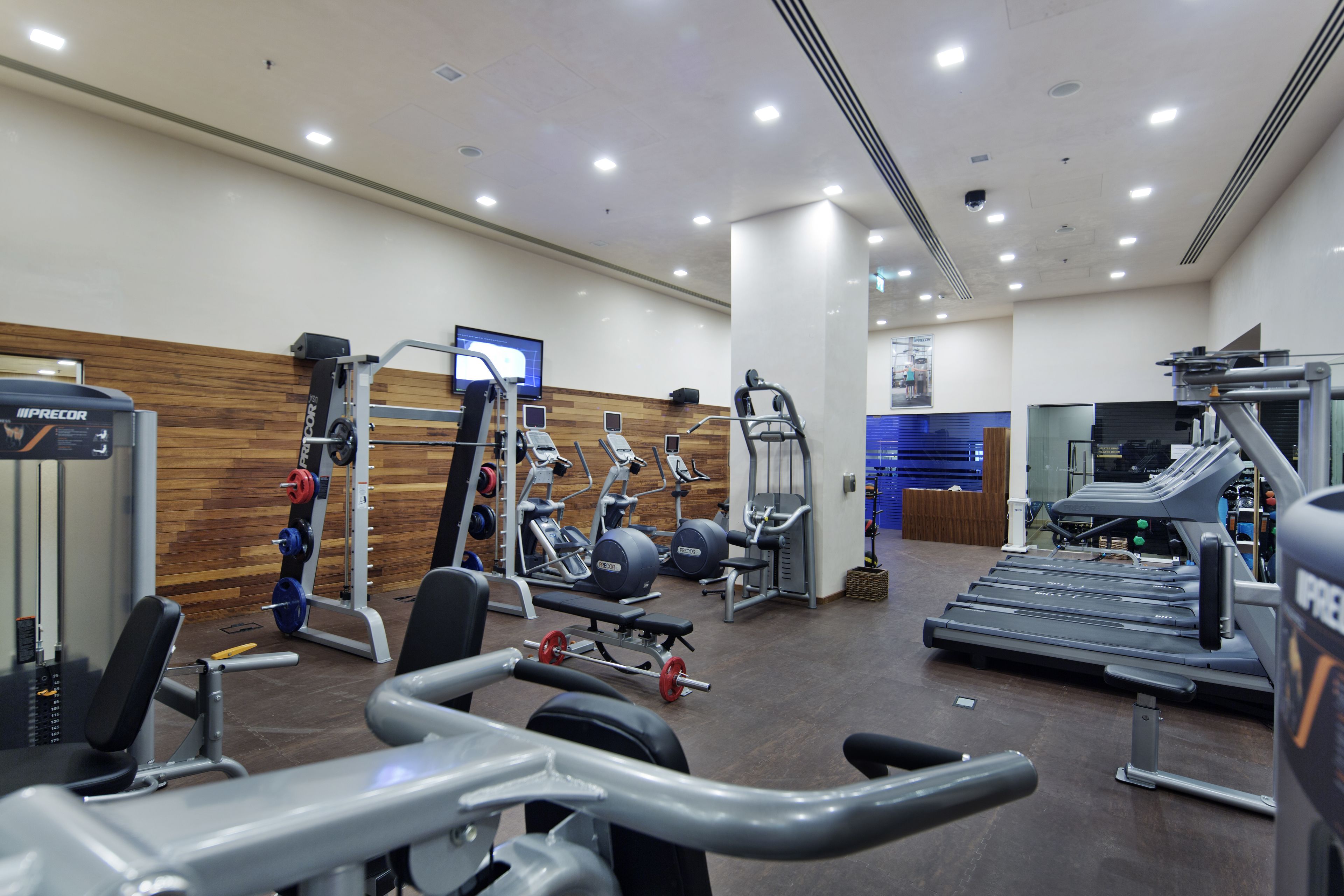 A gym with various exercise equipment, including weight machines, treadmills, and a bench press.