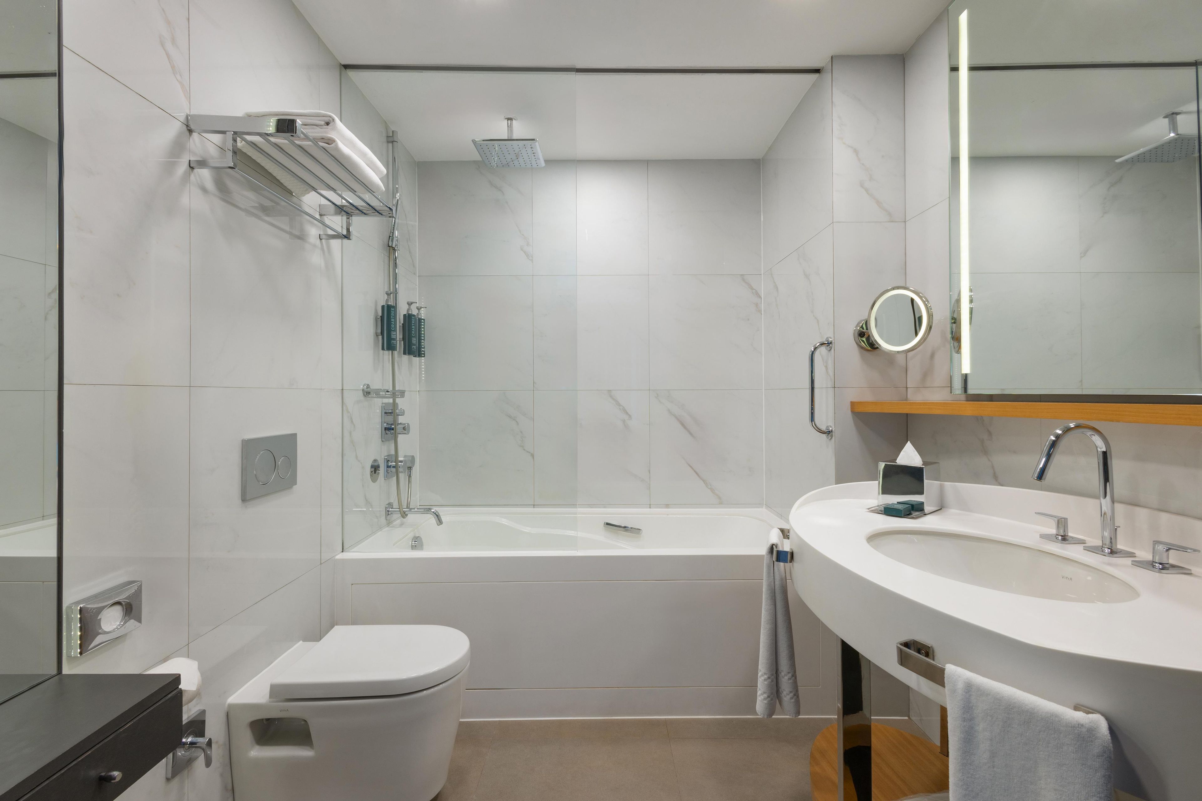A modern bathroom with a toilet, bathtub, and sink.