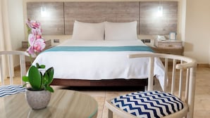 Quarto de hotel com cama, mesa de cabeceira e uma planta em vaso.