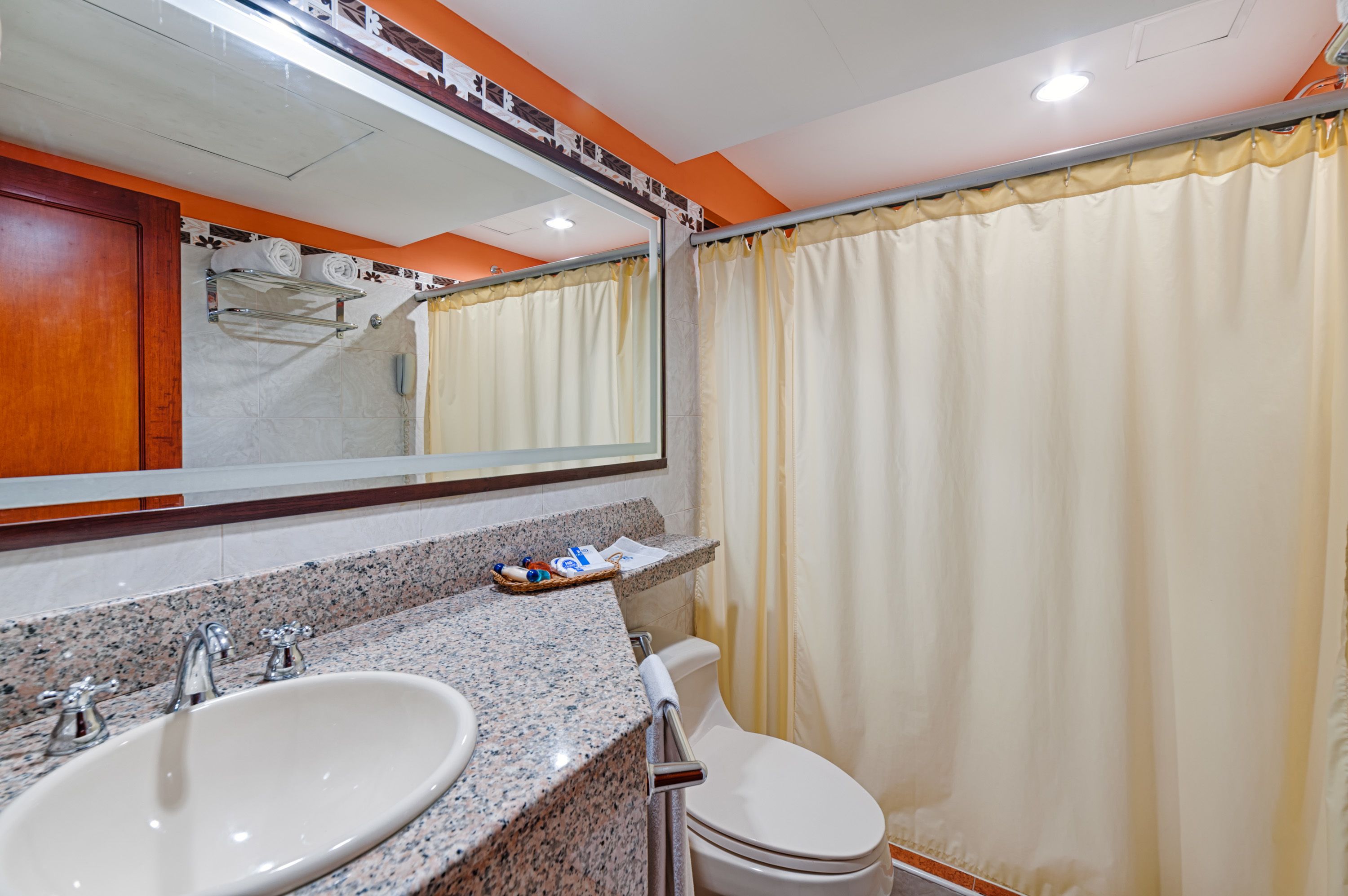 A bathroom with two sinks, a mirror, and a toilet.