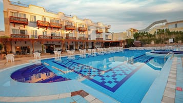 Een buitenzwembad, ligstoelen bij het zwembad