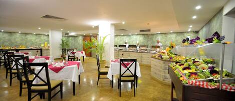 A buffet setup with multiple tables and chairs, a variety of food items, and a clean, well-lit interior.