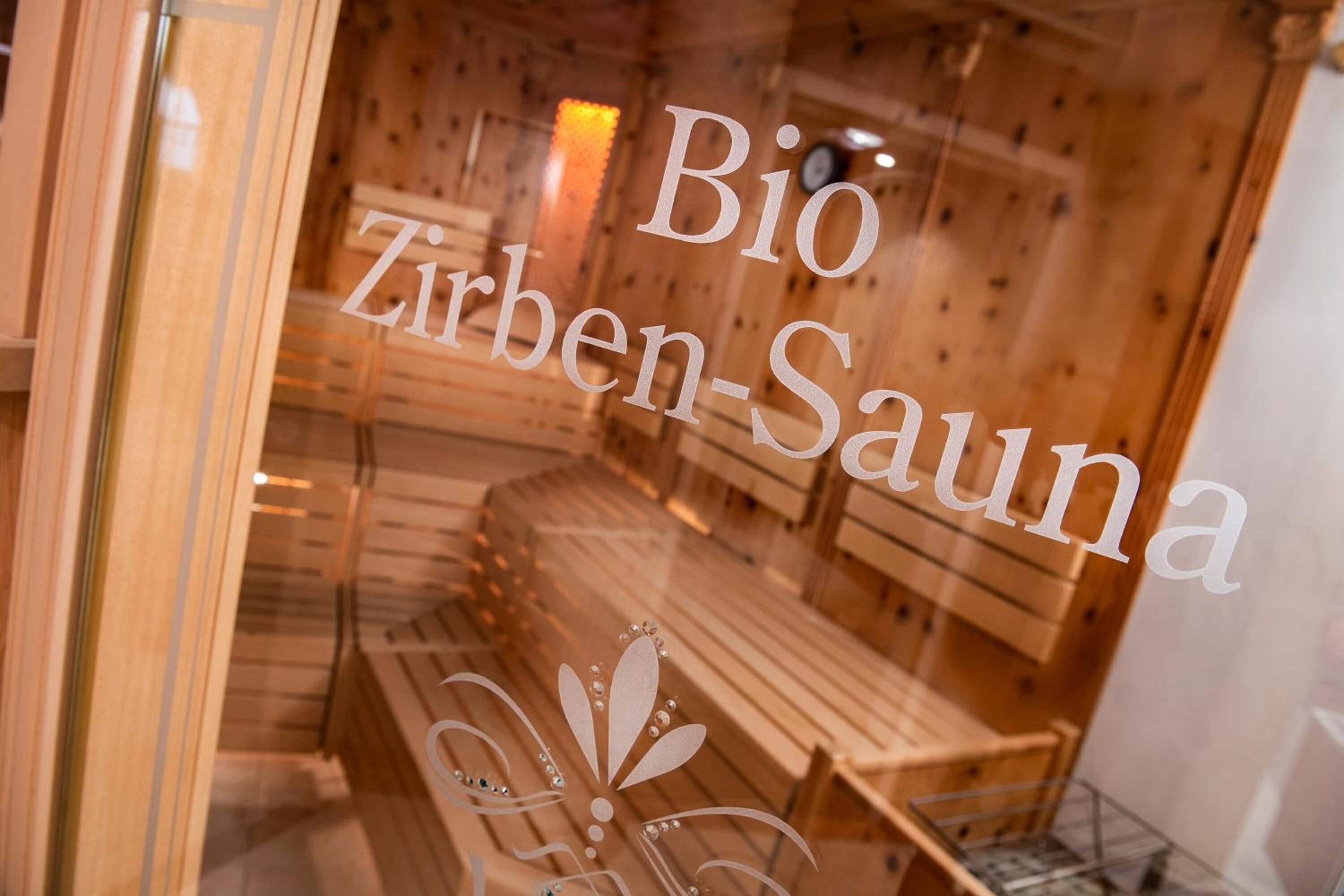 Interior de sauna de madera con bancos y un emblema decorativo.