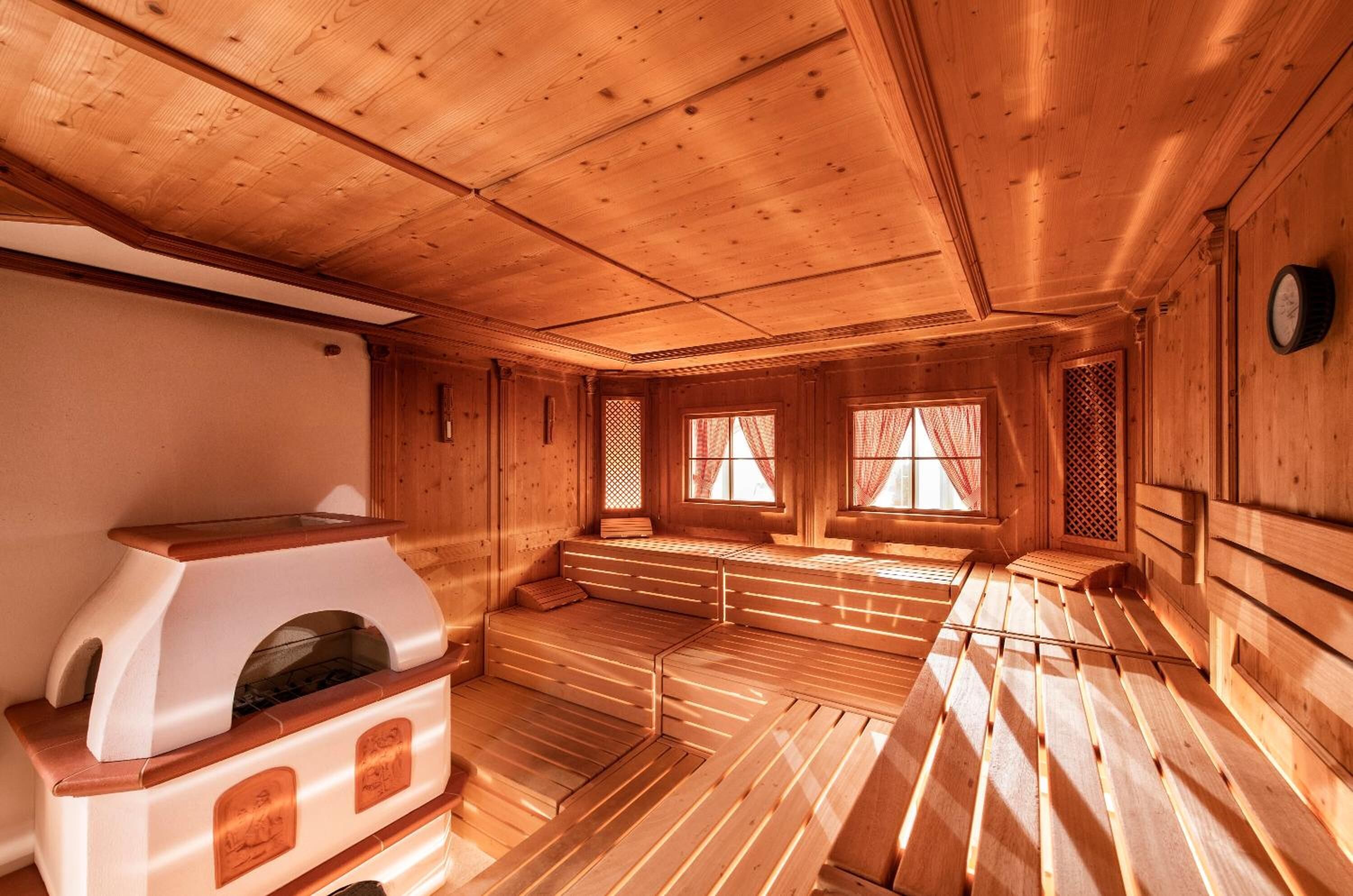 Una sala de sauna con bancos de madera y una unidad de sauna.