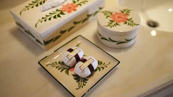 A bathroom with a floral-patterned box and a small container on the counter.