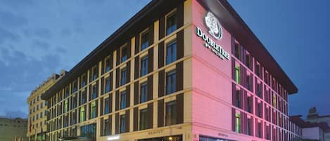 A hotel with a modern facade, multiple floors, and a prominent signage for 'DOUBLET BY HILTON'.