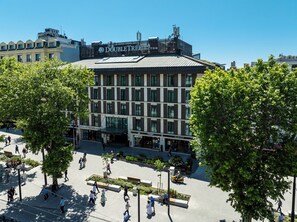 Ein mehrstöckiges Gebäude mit modernem architektonischen Design, das ein auffälliges Schild auf dem Dach trägt.