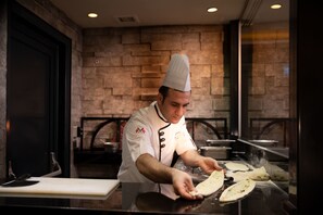 A chef in a professional kitchen preparing dough. - Doubletree By Hilton Istanbul Old Town (Istanbul)