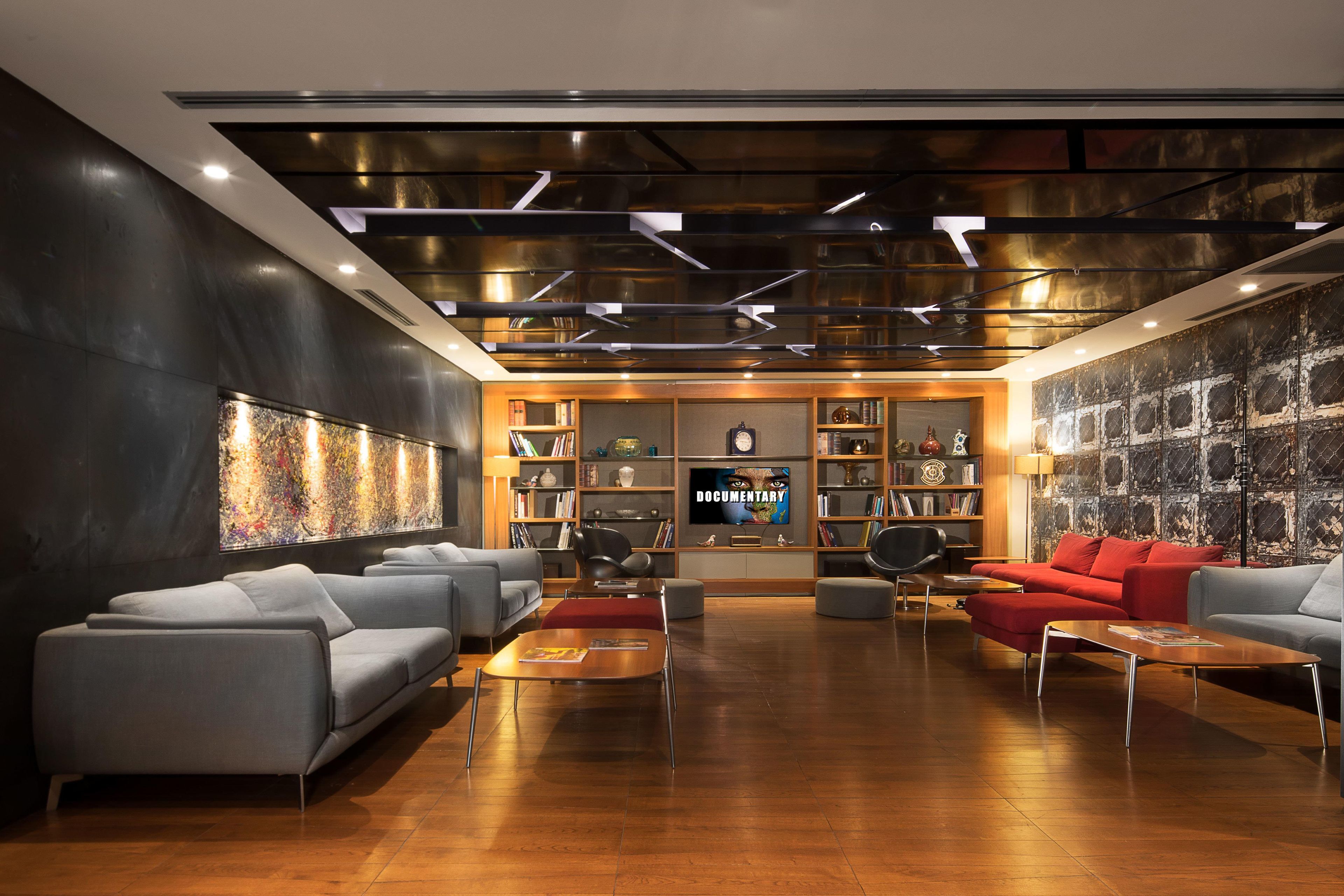 Zona relax moderna con divani, televisore e libreria.