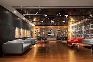 Ein stilvoller Aufenthaltsraum mit Sofas, einem Fernseher und einem Bücherregal.