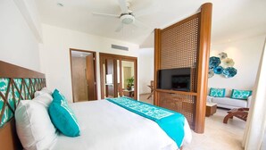 Una habitación de hotel con cama, televisión, sofá y decoración en la pared.