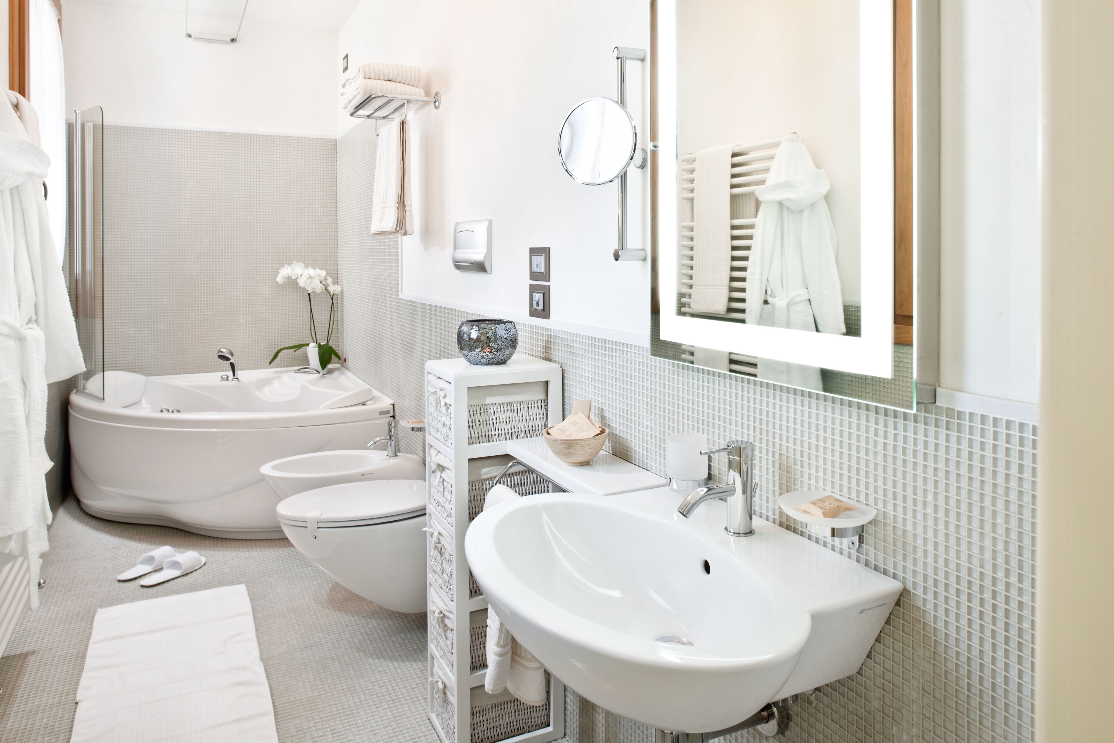 A modern bathroom with a bathtub, toilet, and a large sink.