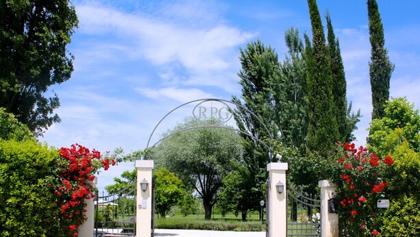 A gated entrance with a sign reading "RPG" and a circular emblem. - Residenza Porta Guelfa (Bevagna)