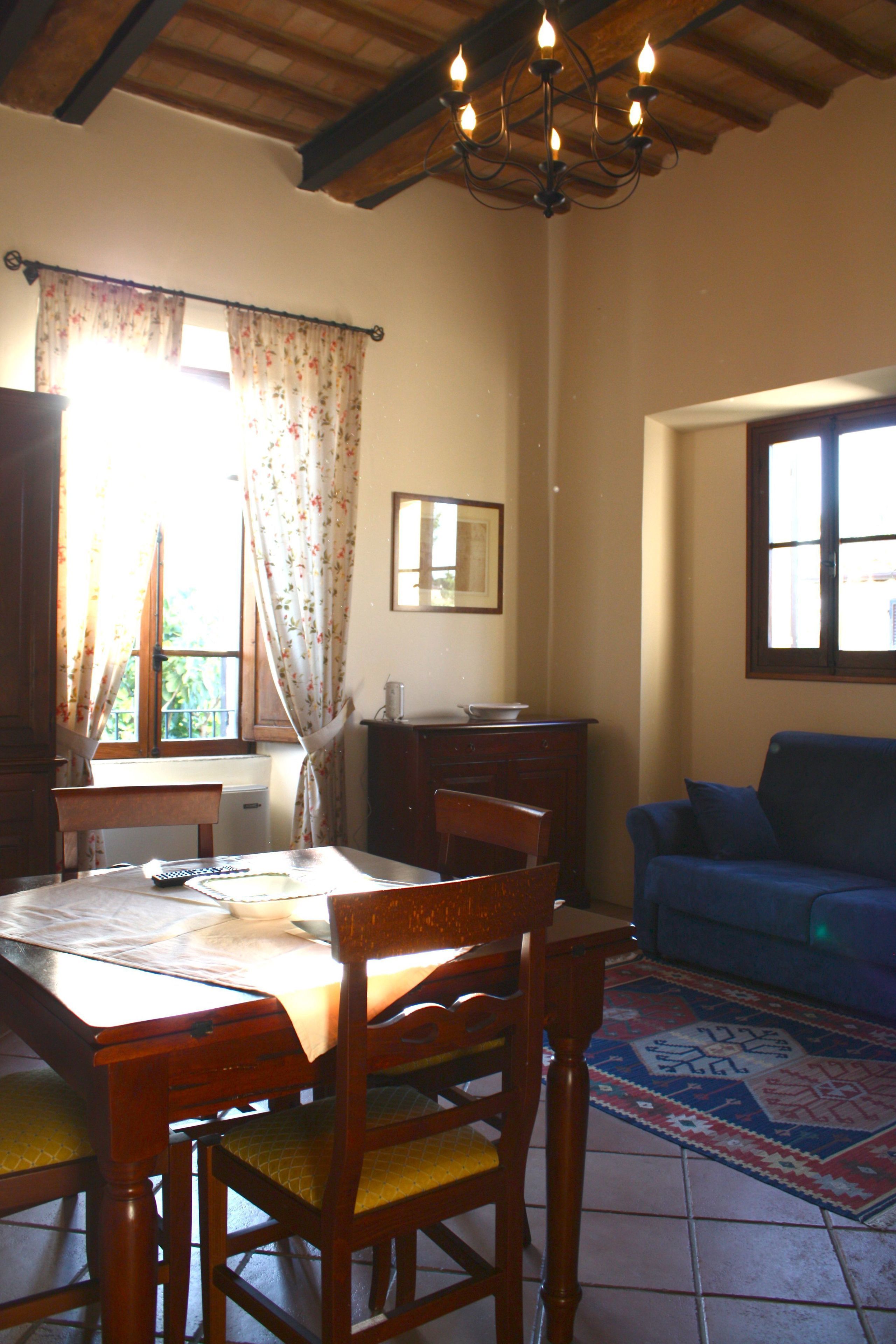 A dining area with a wooden table, chairs, and a blue sofa.