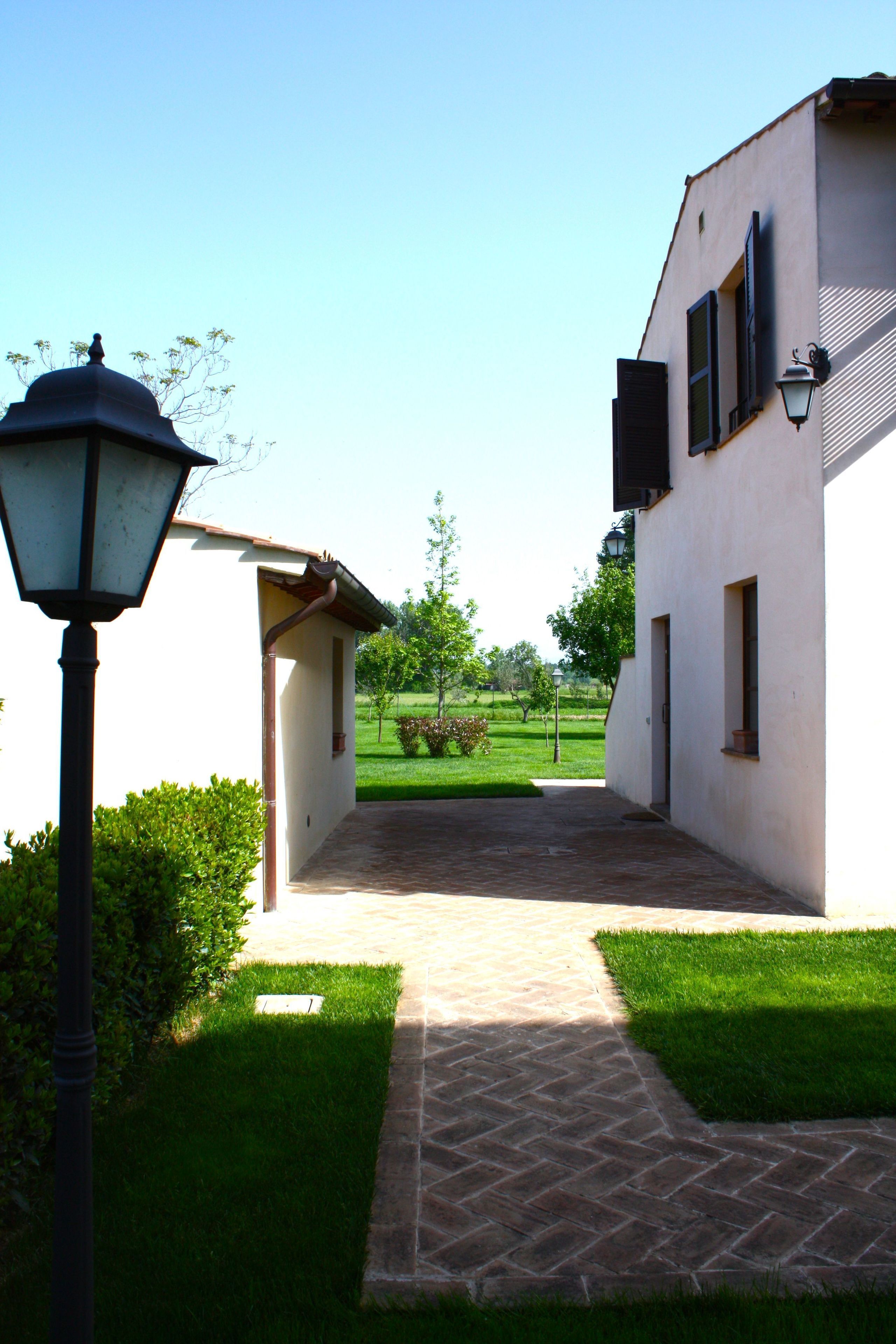 A pathway leading to a building with a lamp post and a clear sky.